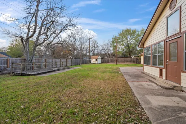 a view of a backyard with wooden fence