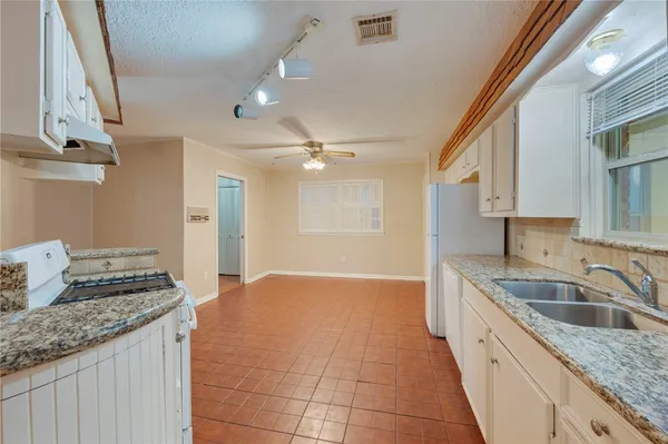 a kitchen with granite countertop a sink and cabinets
