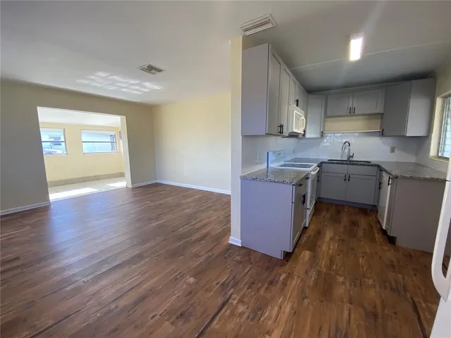 a kitchen with a sink stove cabinets and window
