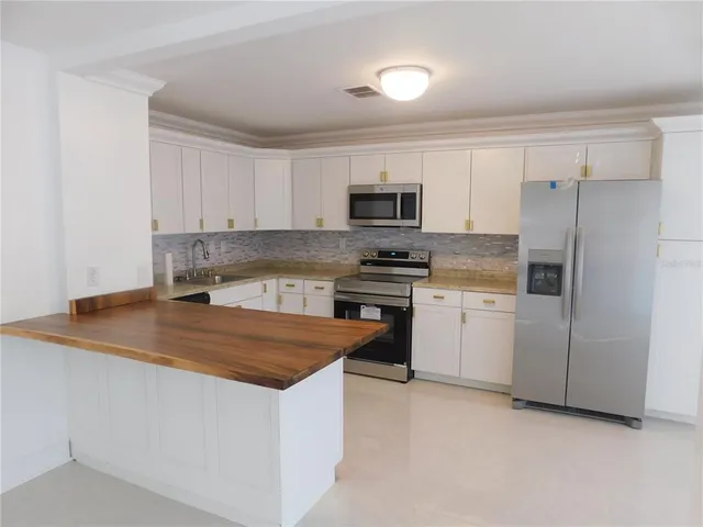 a kitchen with appliances a sink and a counter top space