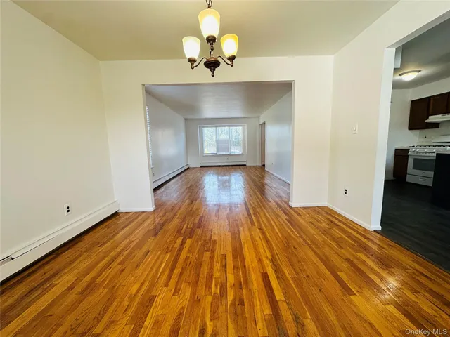 a view of a room with wooden floor and a chandelier