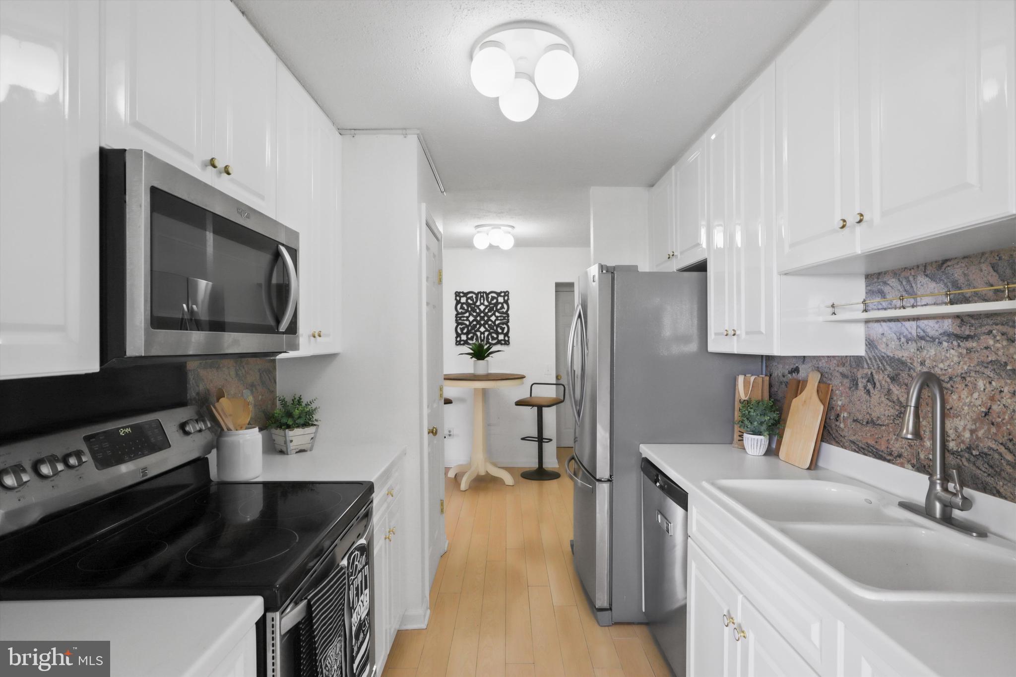 6101 Edsall Road, Unit 611 Alexandria, VA 22304 - Photo 12 of 39 a kitchen with a sink dishwasher a stove and a refrigerator with wooden floor