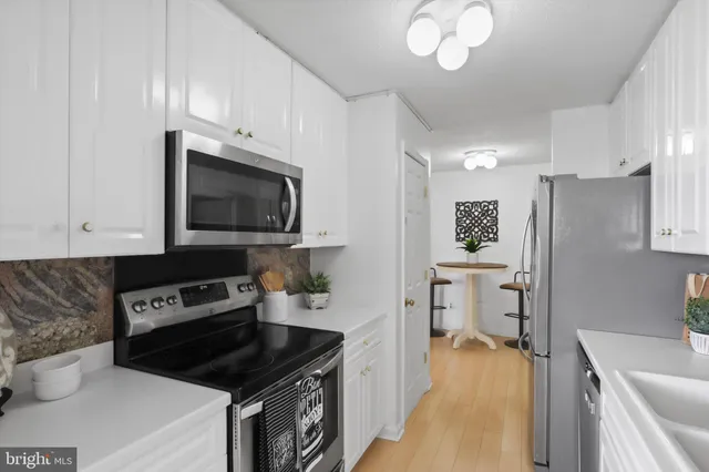 a kitchen with granite countertop a sink stove and cabinets