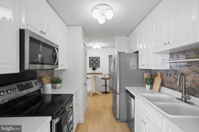 a kitchen with a refrigerator a stove a microwave and island with wooden floor