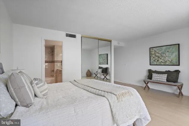 a bedroom with a bed and a painting on the wall