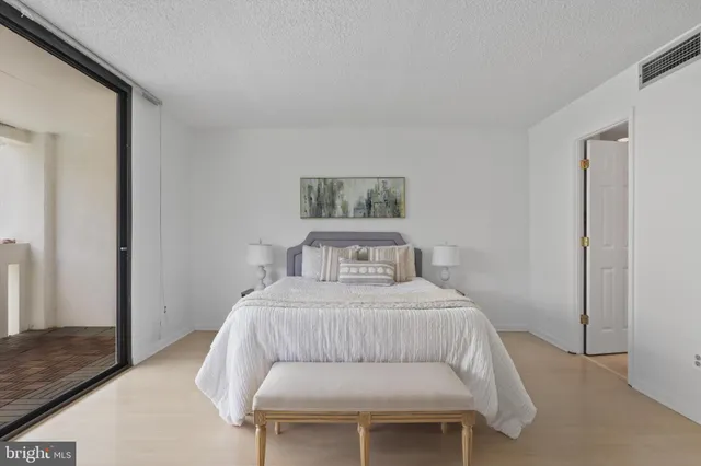 a bedroom with a bed a couch and a window