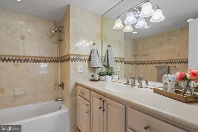 a bathroom with a granite countertop sink a mirror a vanity and a shower