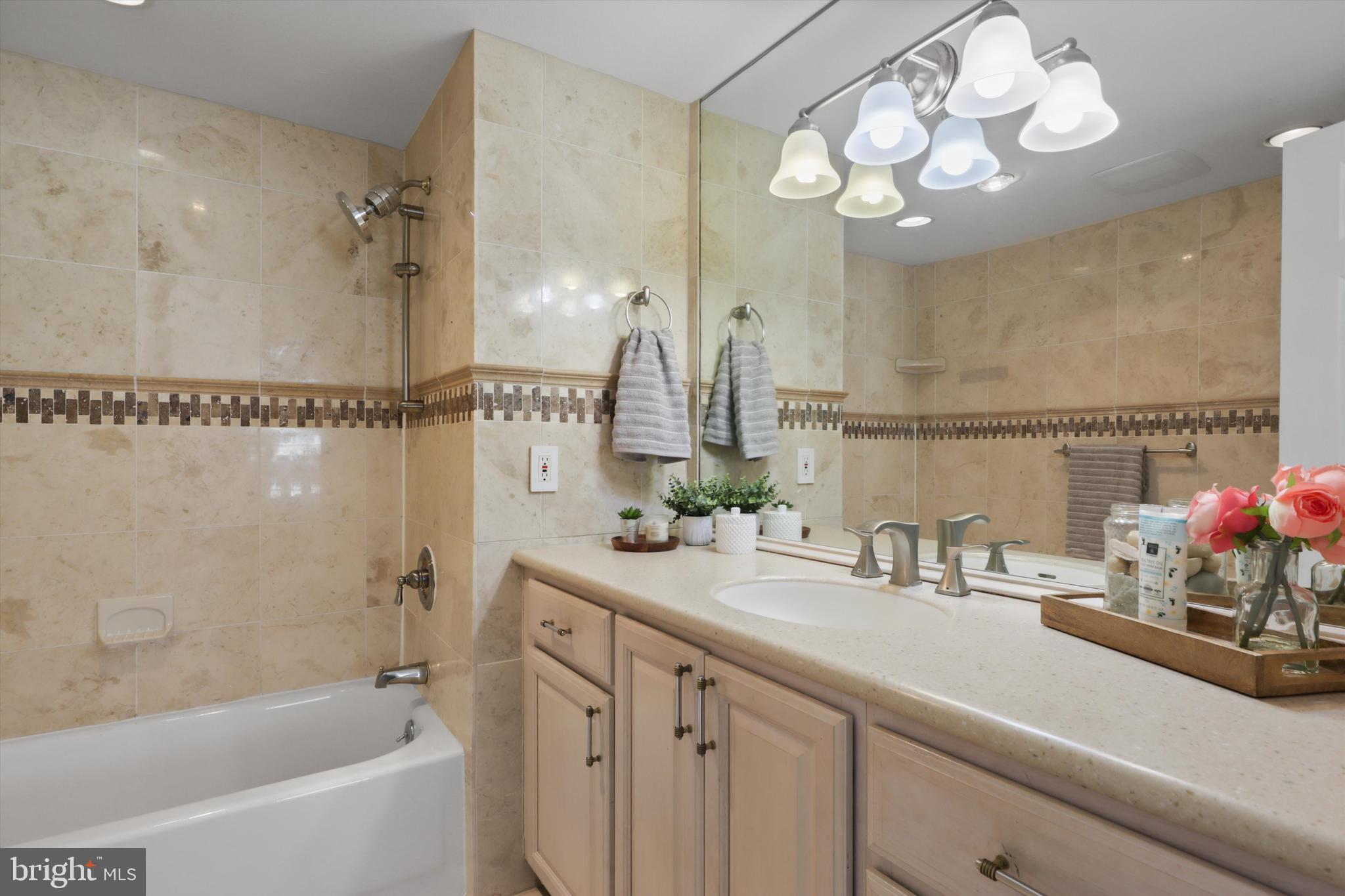 6101 Edsall Road, Unit 611 Alexandria, VA 22304 - Photo 29 of 39 a bathroom with a sink a mirror a bathtub and shower