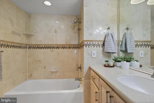 a bathroom with a sink a large mirror and a bathtub