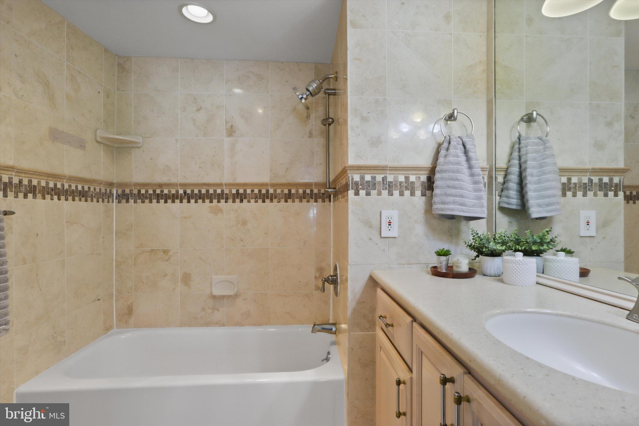 6101 Edsall Road, Unit 611 Alexandria, VA 22304 - Photo 30 of 39 a bathroom with a granite countertop sink a mirror a vanity and a shower