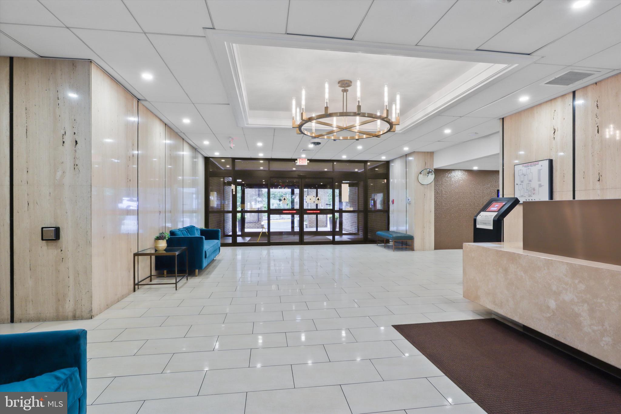 6101 Edsall Road, Unit 611 Alexandria, VA 22304 - Photo 7 of 39 a view of an empty room with a chandelier fan and kitchen view