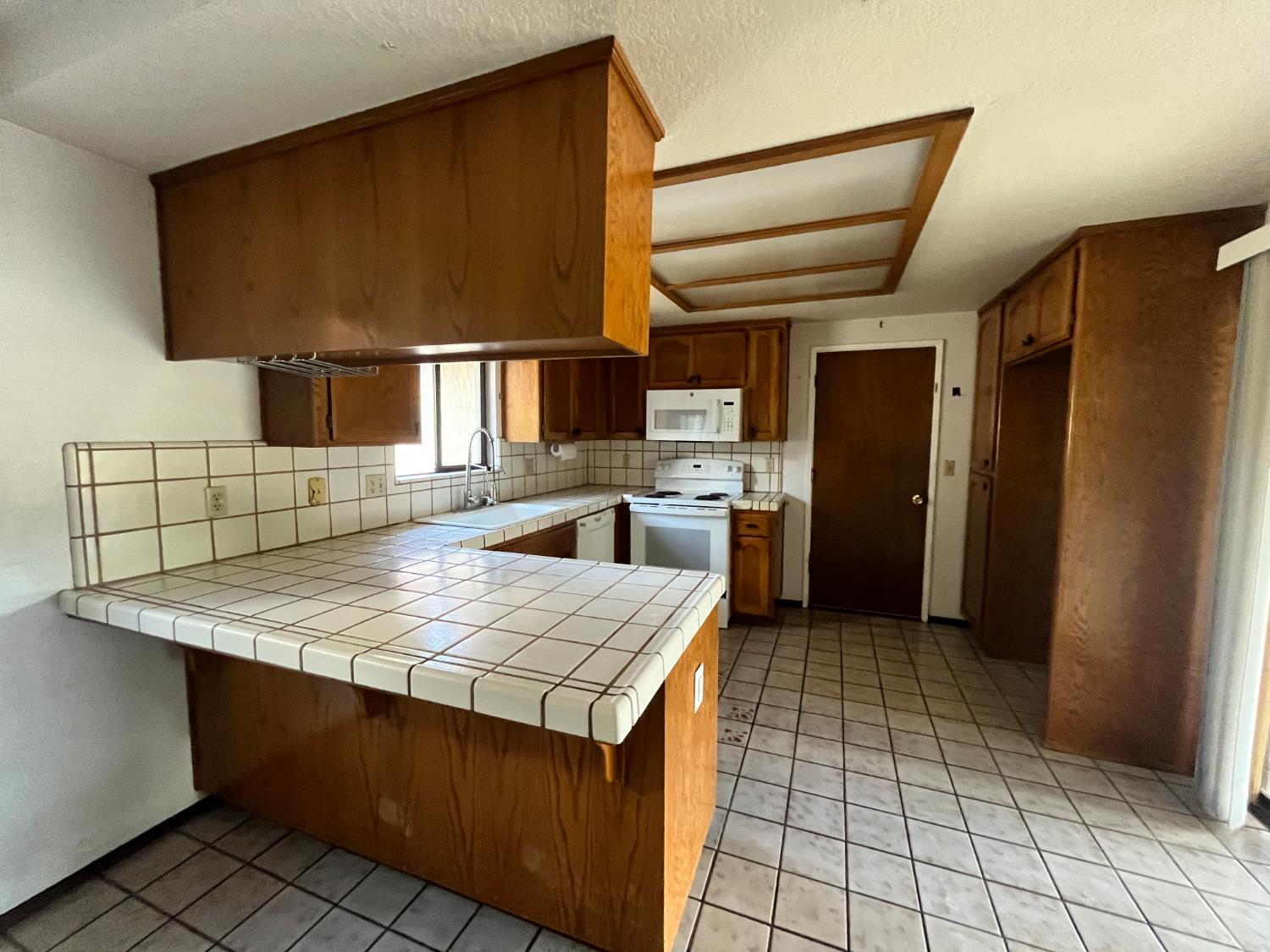 312 Roxanne Drive Patterson, CA 95363 - Photo 16 of 28 a kitchen with a sink a refrigerator and cabinets
