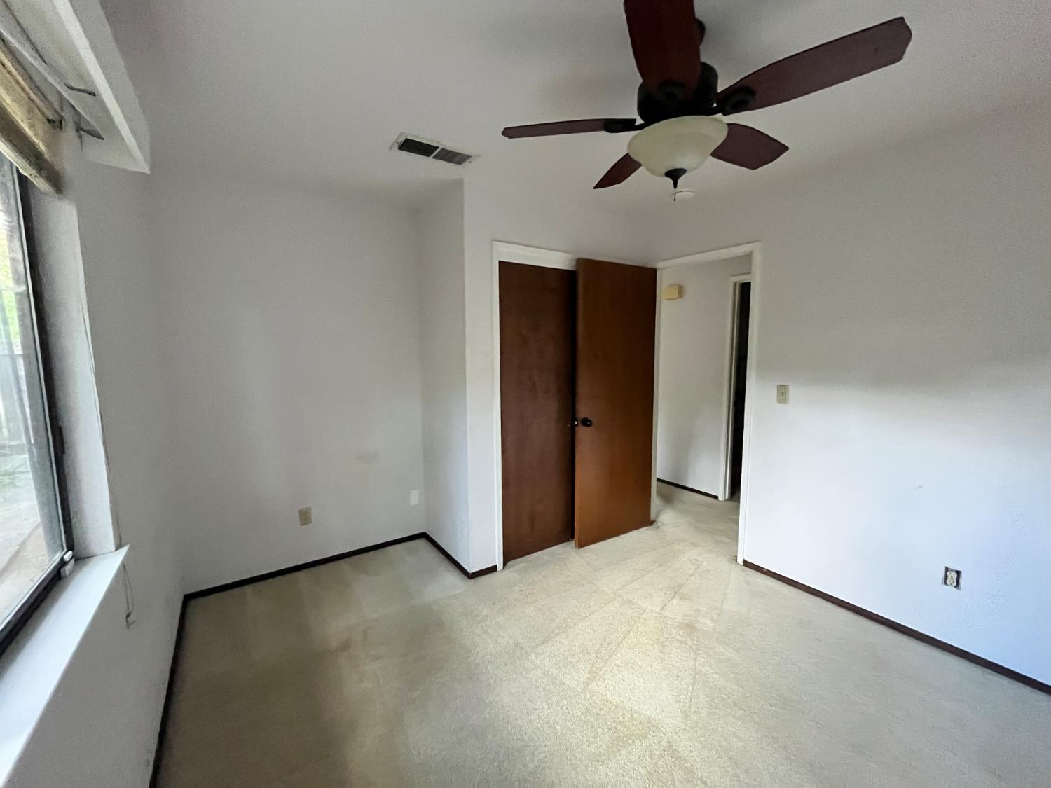 312 Roxanne Drive Patterson, CA 95363 - Photo 17 of 28 an empty room with a ceiling fan and window