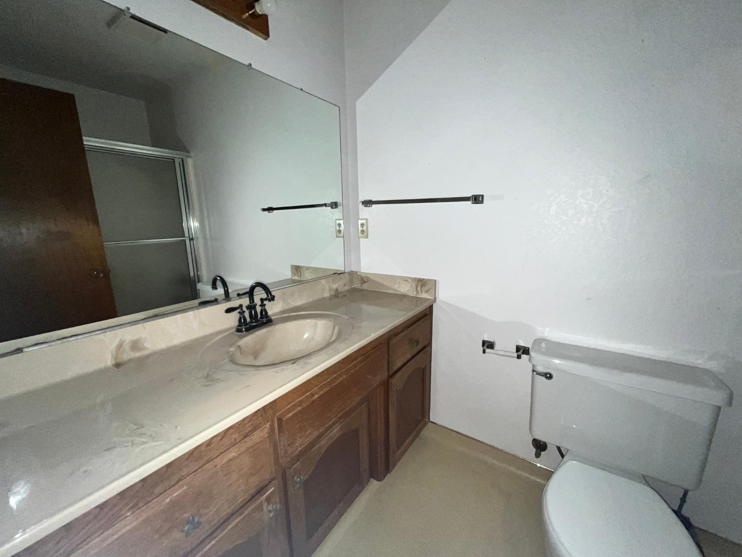 312 Roxanne Drive Patterson, CA 95363 - Photo 21 of 28 a bathroom with a granite countertop sink a mirror and a toilet