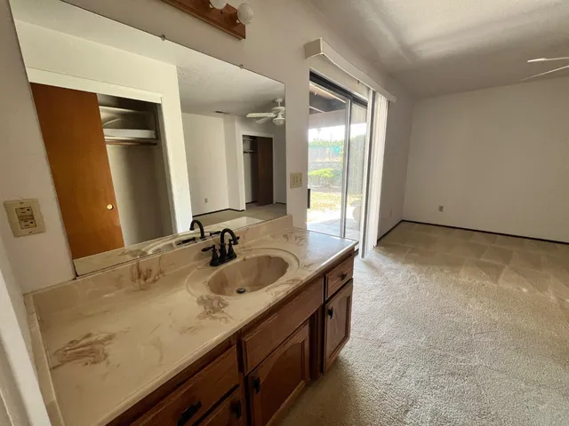 a bathroom with a granite countertop sink and a mirror