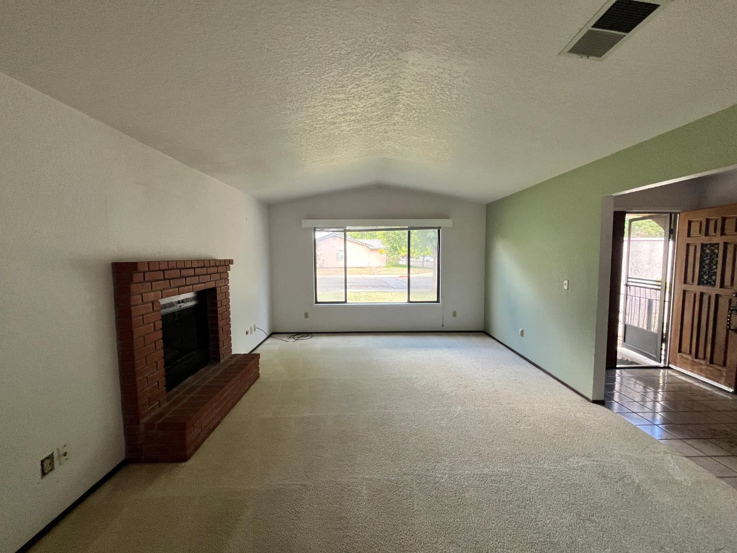 312 Roxanne Drive Patterson, CA 95363 - Photo 9 of 28 an empty room with windows and fireplace
