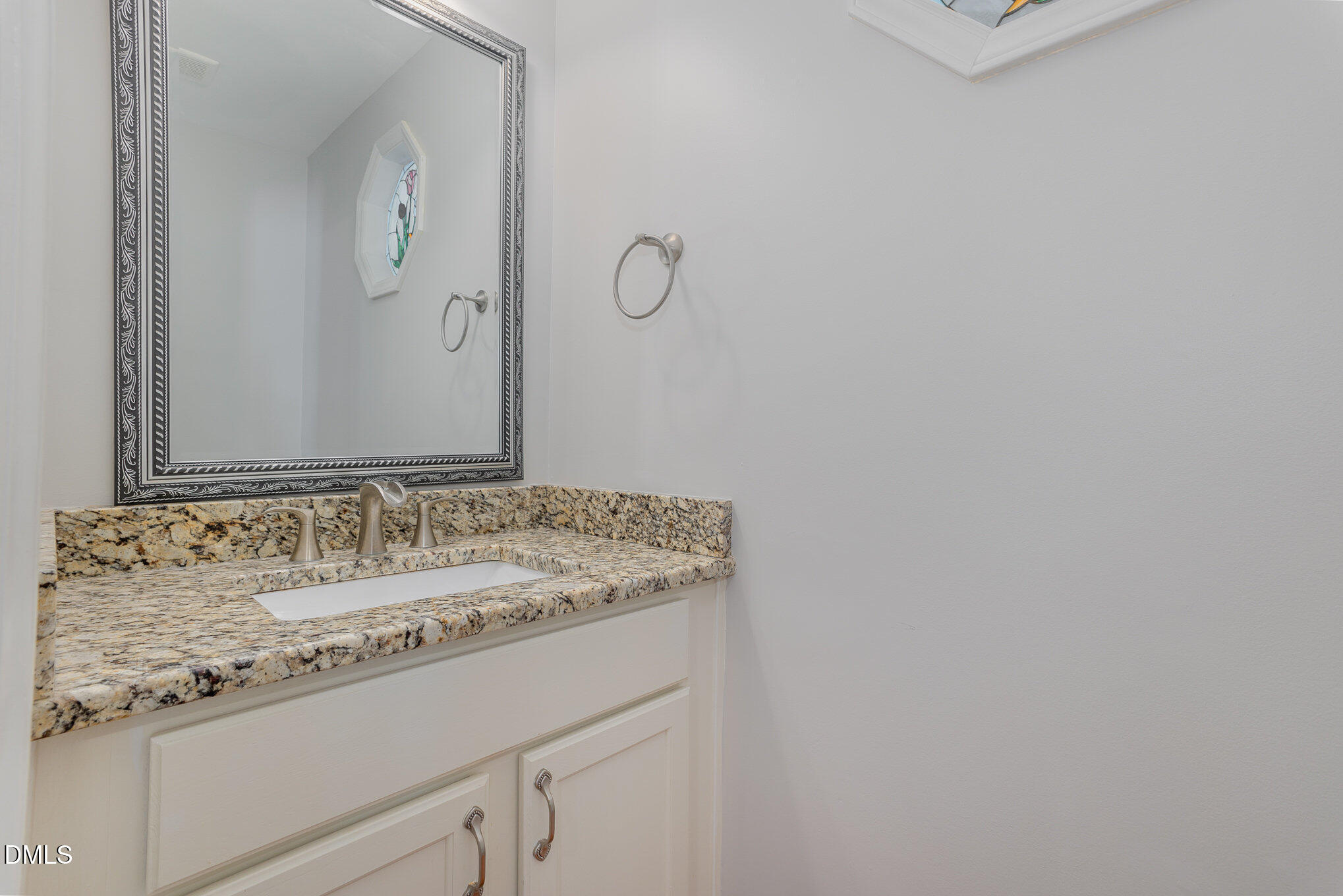 1437 Greenside Drive Raleigh, NC 27609 - Photo 22 of 27 a bathroom with a granite countertop sink and a mirror