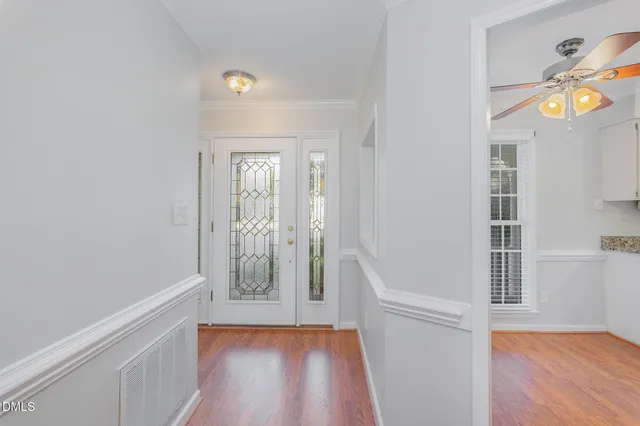 a view of an entryway with wooden floor and a livingroom
