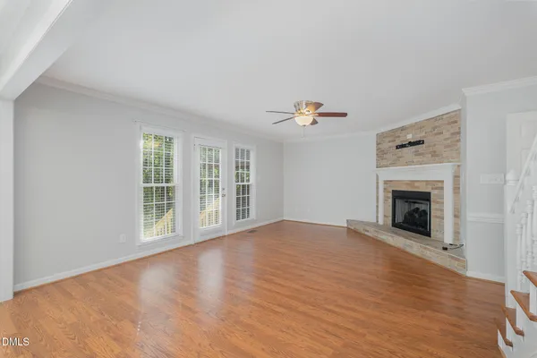 a view of a livingroom with wooden floor and kitchen space