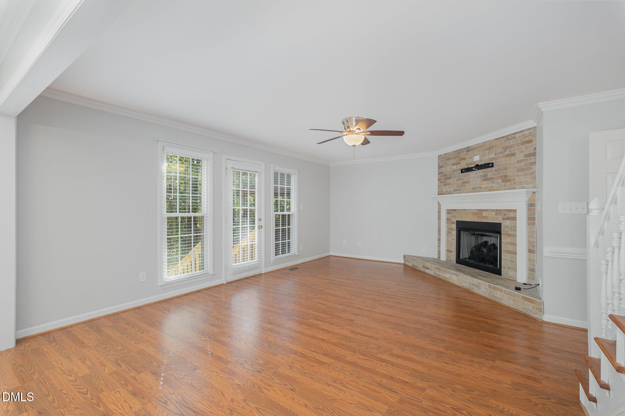 1437 Greenside Drive Raleigh, NC 27609 - Photo 10 of 27 a view of an empty room with wooden floor fireplace and a window