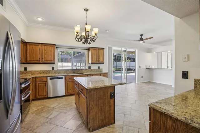 a kitchen with kitchen island granite countertop stainless steel appliances a sink stove and refrigerator