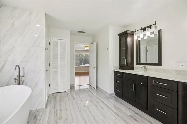 a bathroom with a granite countertop sink a toilet a mirror and shower