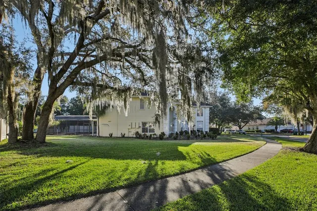 a white house that has a tree in front of it