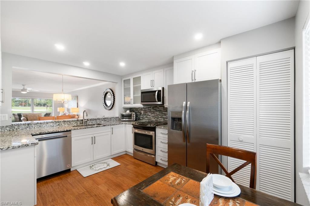 4572 Andover Way, Unit C105 Naples, FL 34112 - Photo 11 of 50 a kitchen with stainless steel appliances granite countertop a refrigerator a stove microwave and sink