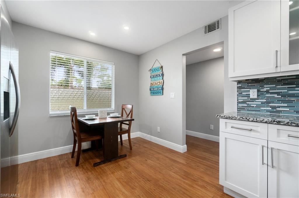 4572 Andover Way, Unit C105 Naples, FL 34112 - Photo 14 of 50 a view of a dining room with furniture and wooden floor