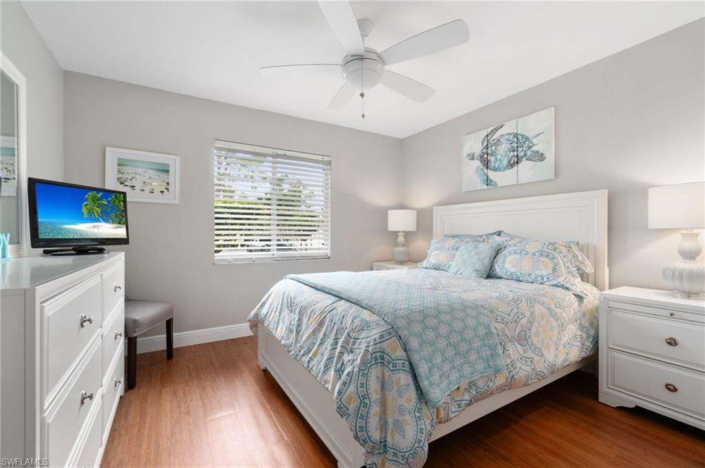 4572 Andover Way, Unit C105 Naples, FL 34112 - Photo 16 of 50 a bedroom with a bed and a flat tv screen on dresser