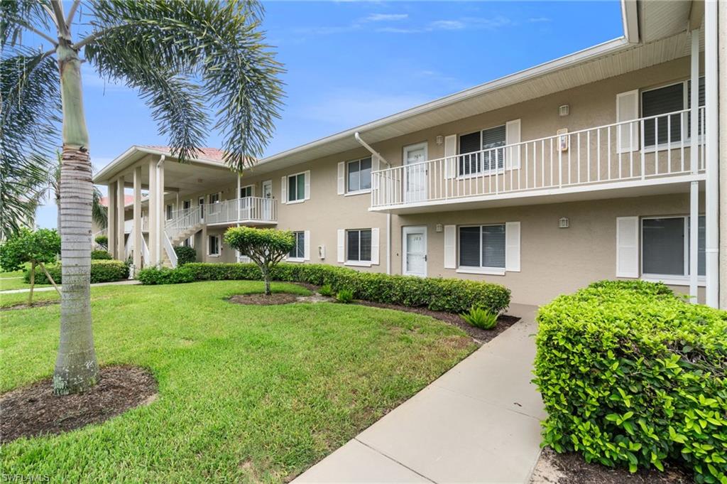 4572 Andover Way, Unit C105 Naples, FL 34112 - Photo 2 of 50 a front view of a house with a yard