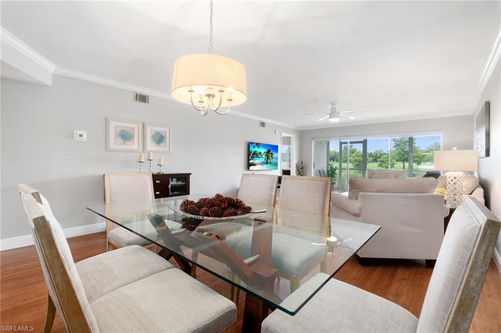 4572 Andover Way, Unit C105 Naples, FL 34112 - Photo 23 of 50 a view of a dining room with furniture and a chandelier