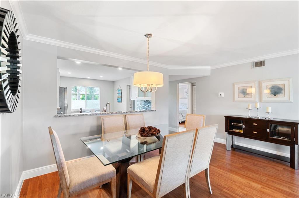 4572 Andover Way, Unit C105 Naples, FL 34112 - Photo 24 of 50 a view of a dining room with furniture and wooden floor