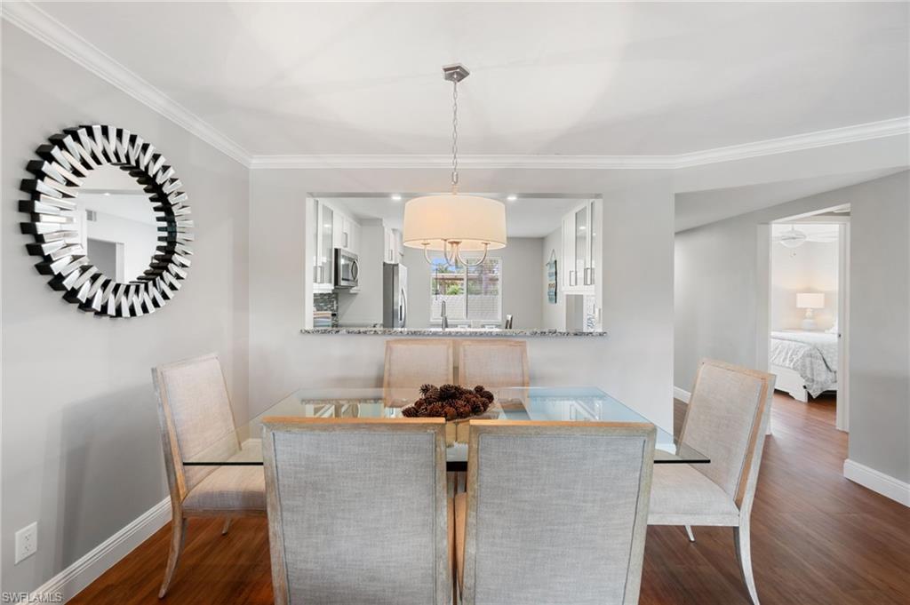 4572 Andover Way, Unit C105 Naples, FL 34112 - Photo 25 of 50 a view of a dining room with furniture window and wooden floor