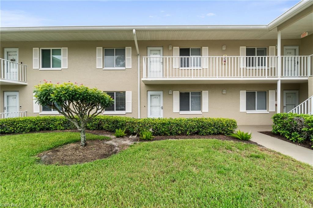4572 Andover Way, Unit C105 Naples, FL 34112 - Photo 3 of 50 a front view of a house with garden and trees