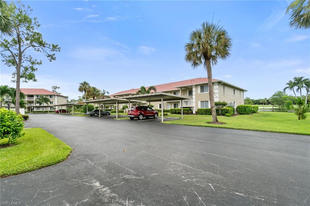 4572 Andover Way, Unit C105 Naples, FL 34112 - Photo 50 of 50 a car parked in front of a house with a big yard
