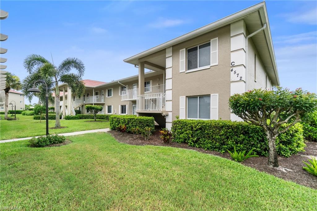 4572 Andover Way, Unit C105 Naples, FL 34112 - Photo 5 of 50 a front view of a house with a yard