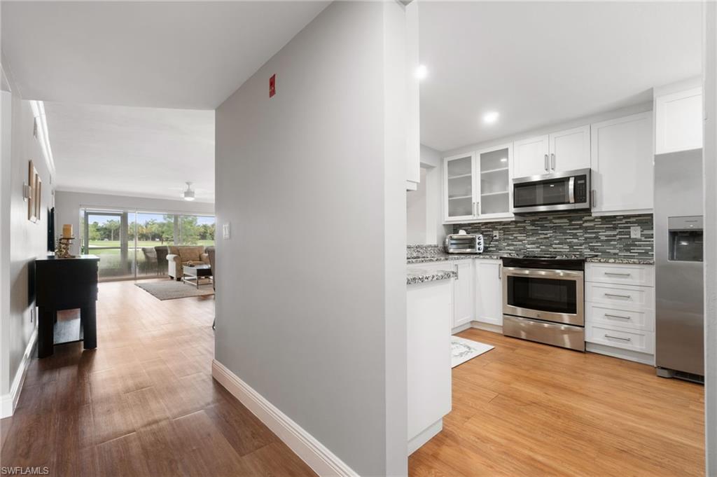 4572 Andover Way, Unit C105 Naples, FL 34112 - Photo 6 of 50 a view of living room kitchen with furniture and fireplace