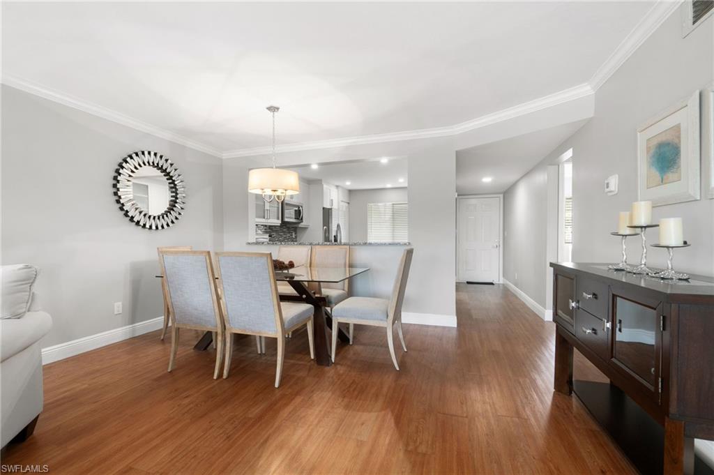 4572 Andover Way, Unit C105 Naples, FL 34112 - Photo 7 of 50 a view of a dining room with furniture and wooden floor