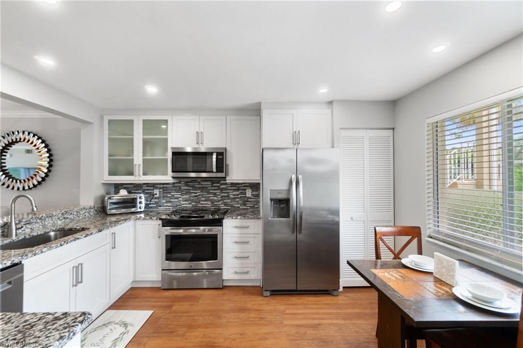 4572 Andover Way, Unit C105 Naples, FL 34112 - Photo 9 of 50 a kitchen with stainless steel appliances granite countertop a refrigerator stove top oven and sink