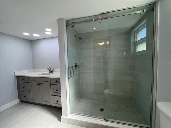 a bathroom with a shower sink and mirror