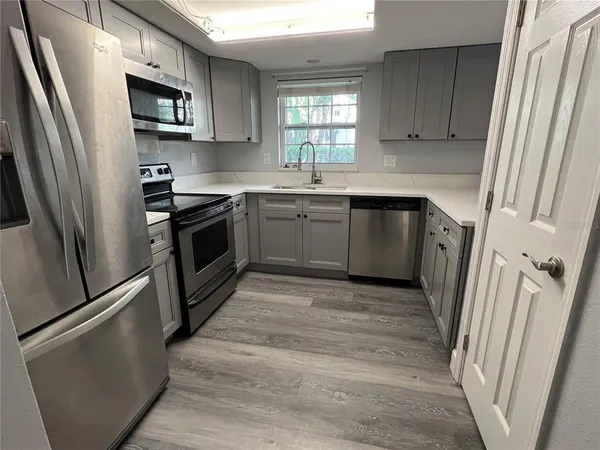 a kitchen with stainless steel appliances a refrigerator sink and microwave