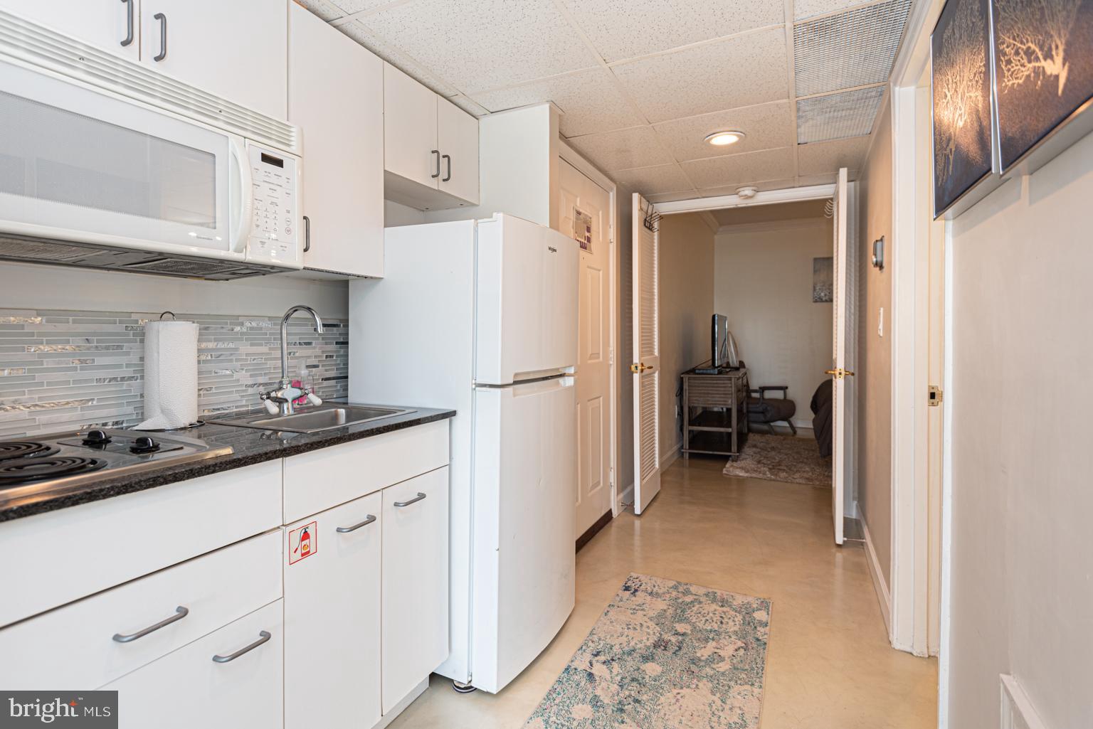 200 59th Street, Unit 209 Ocean City, MD 21842 - Photo 13 of 49 a kitchen with refrigerator and window