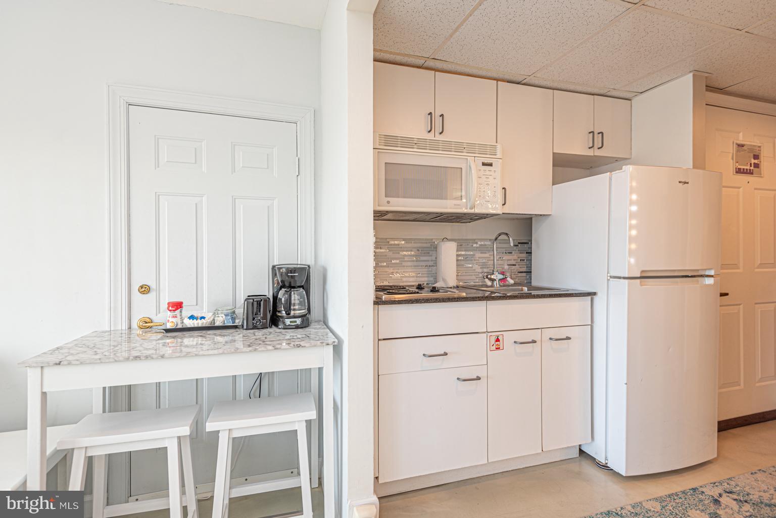 200 59th Street, Unit 209 Ocean City, MD 21842 - Photo 14 of 49 a kitchen with stainless steel appliances granite countertop a refrigerator sink and cabinets