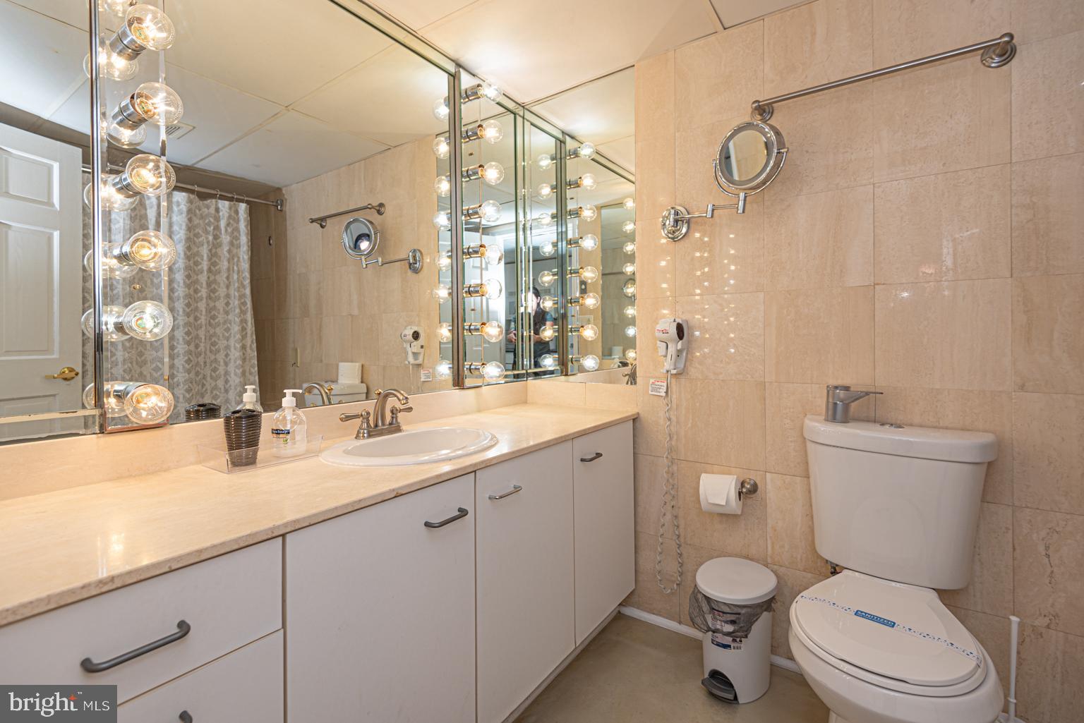 200 59th Street, Unit 209 Ocean City, MD 21842 - Photo 17 of 49 a bathroom with a sink a toilet and a large mirror
