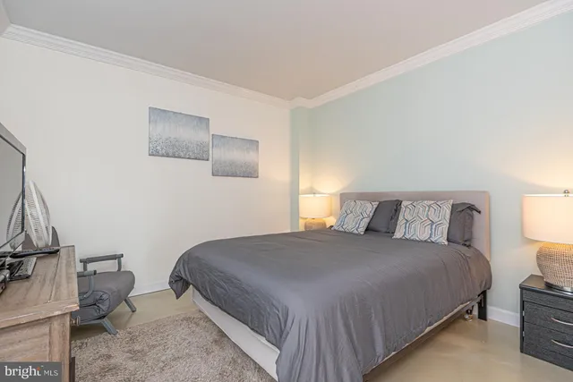 a bedroom with a bed and a lamp with the dresser