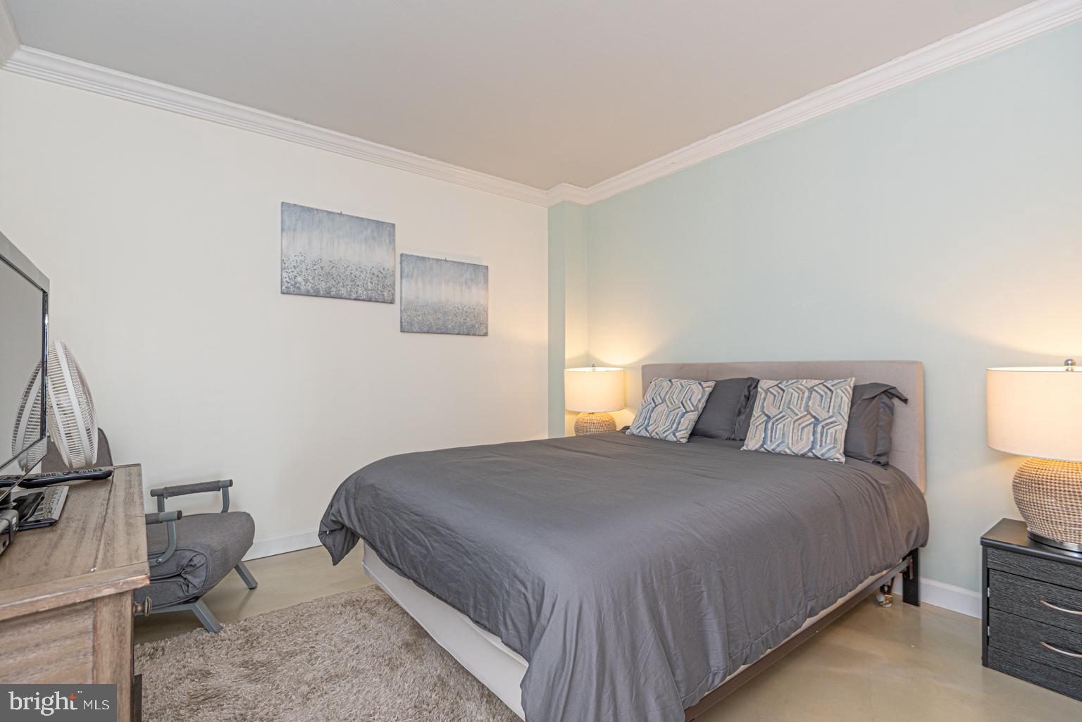 200 59th Street, Unit 209 Ocean City, MD 21842 - Photo 21 of 49 a bedroom with a bed and a lamp with the dresser