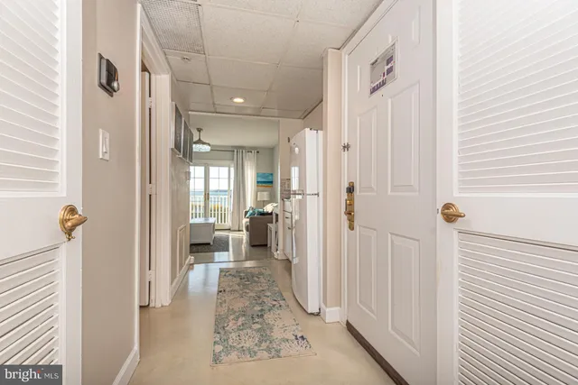 a view of a hallway with a livingroom and furniture