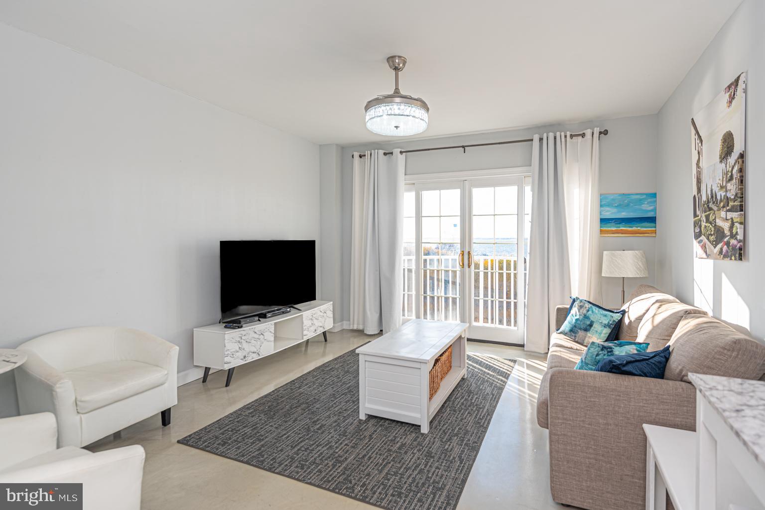 200 59th Street, Unit 209 Ocean City, MD 21842 - Photo 3 of 49 a living room with furniture and a flat screen tv