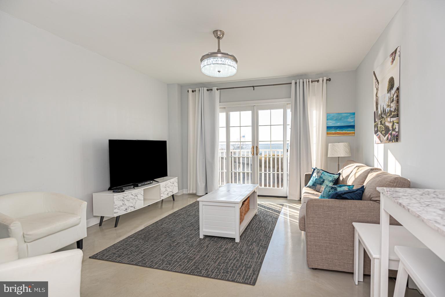 200 59th Street, Unit 209 Ocean City, MD 21842 - Photo 4 of 49 a living room with furniture and a flat screen tv
